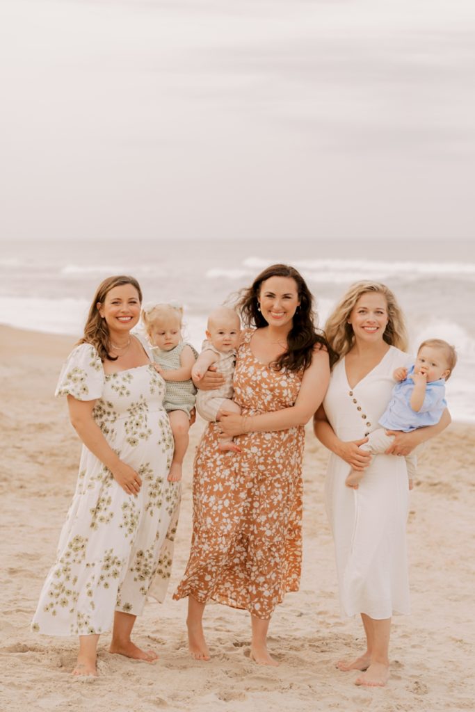 women holding babies by ocean outer banks photos by sharon elizabeth co