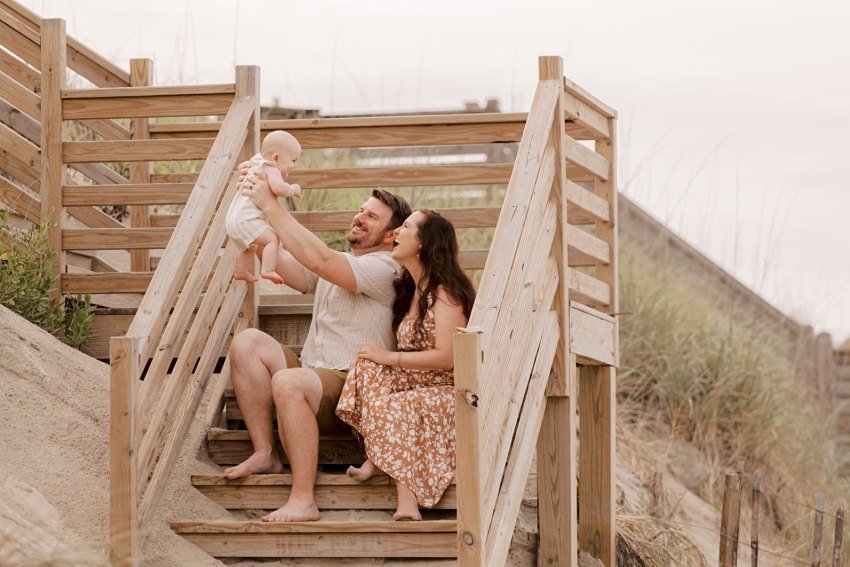 couple playing with baby on stairs outer banks photos by sharon elizabeth co