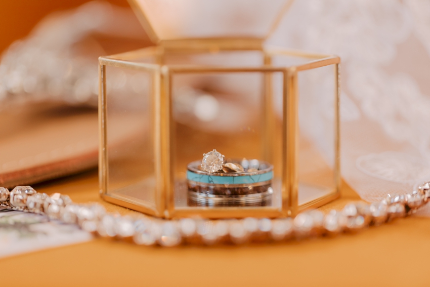 wedding rings in glass jewelry box by sharon elizabeth co