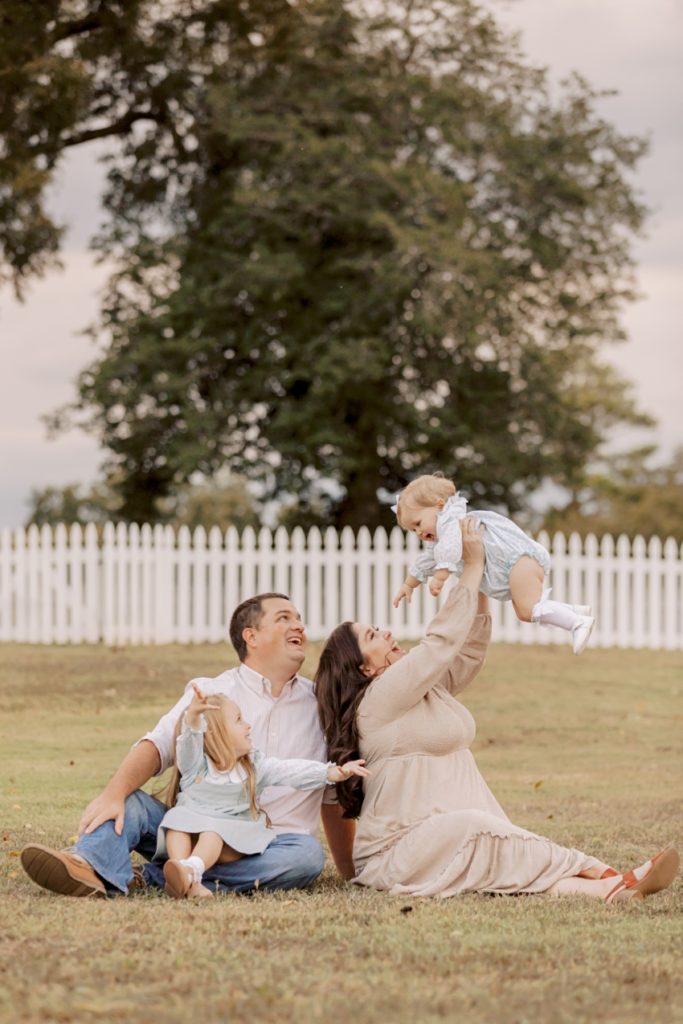 little girl in air as family poses | Family Session in Smithfield, Virginia by Sharon Elizabeth Co