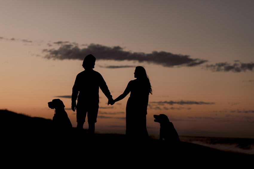shadow of couple with dogs on the beach at sunset in nags head, nc by sharon elizabeth co