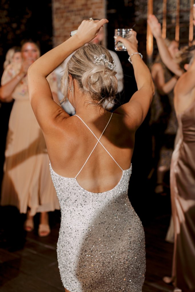 bride in white sequin cocktail dress dancing at reception by sharon elizabeth co
