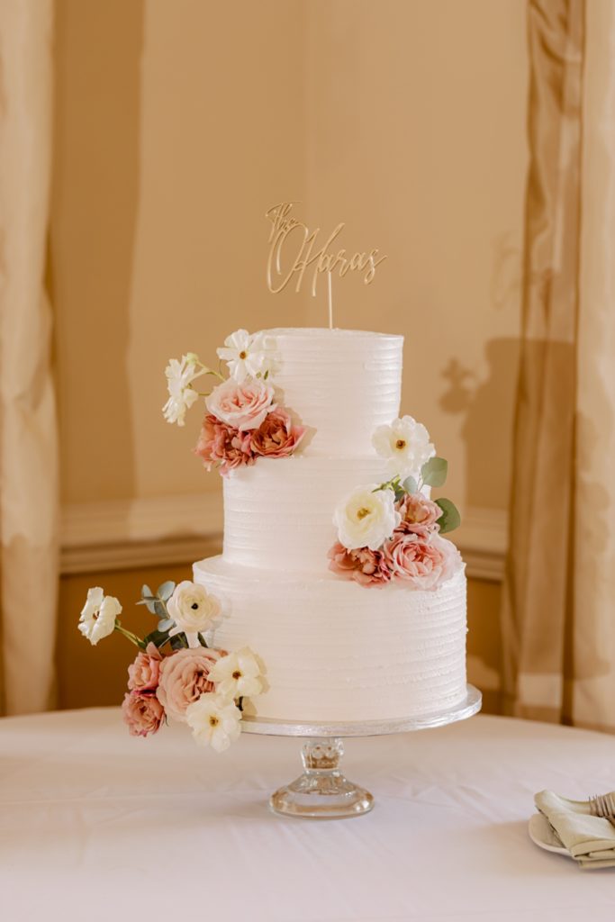 classic white wedding cake with pink and white flowers by sharon elizabeth co