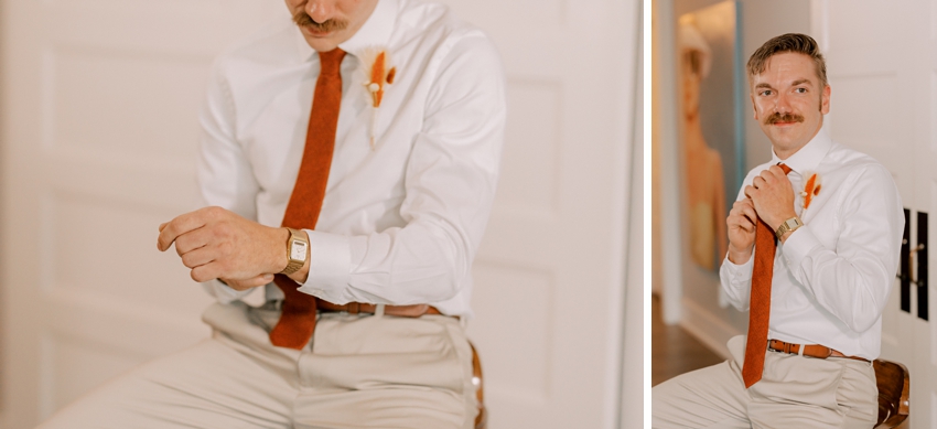 groom prepares for wedding day adjusting red tie 