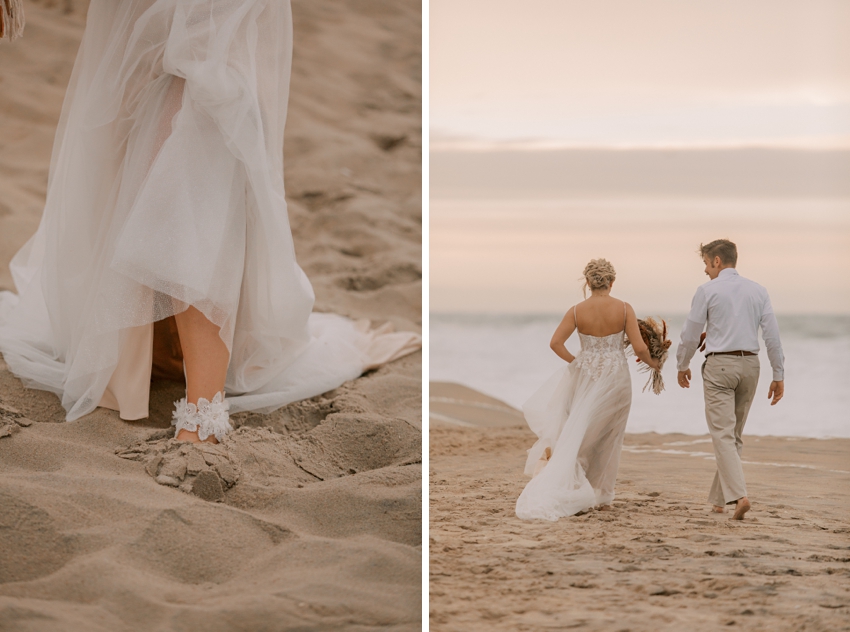 bride and groom hold hands walking towards ocean at sunset 