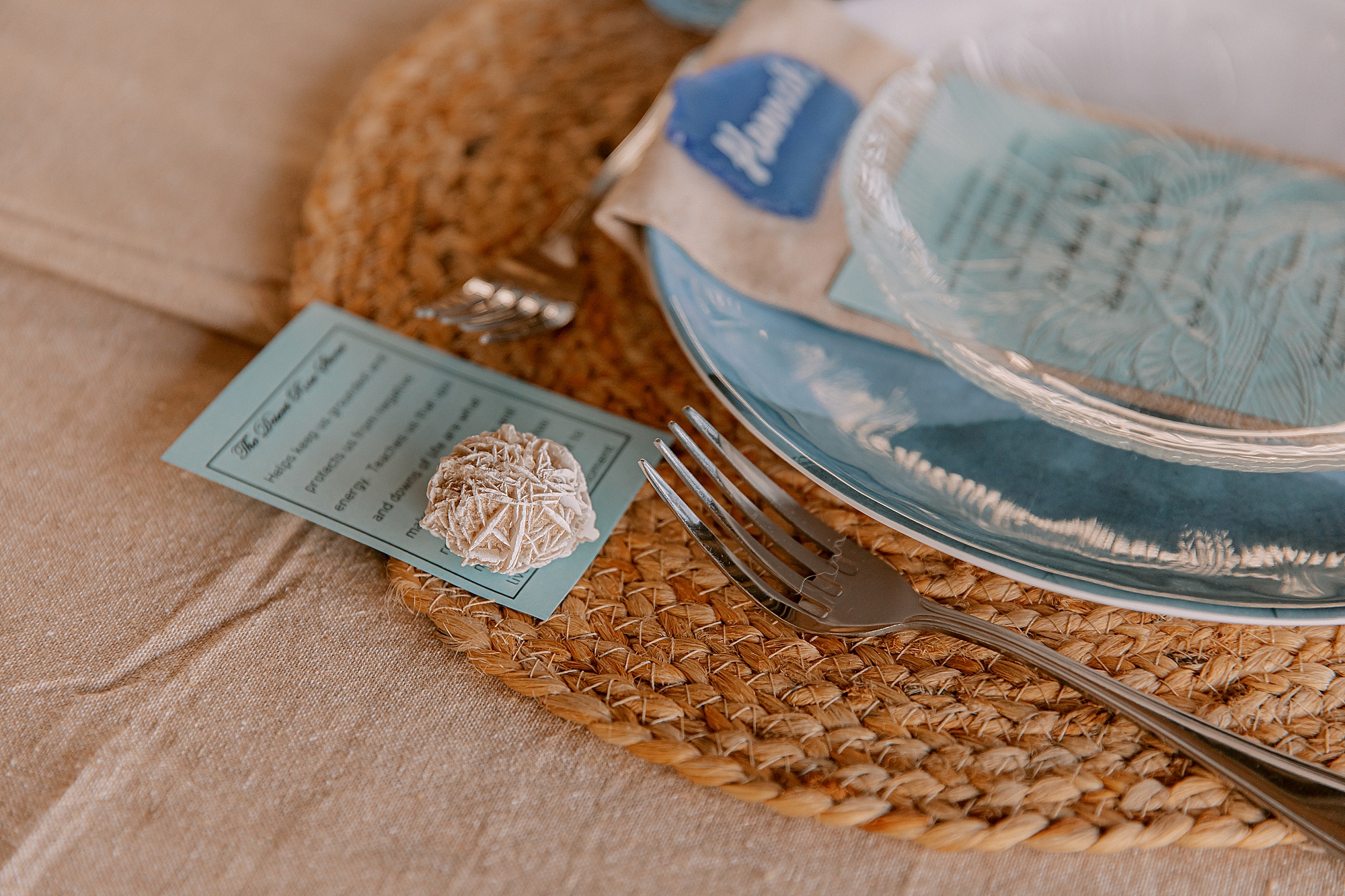 wedding reception place setting with blue paper and glass plates 