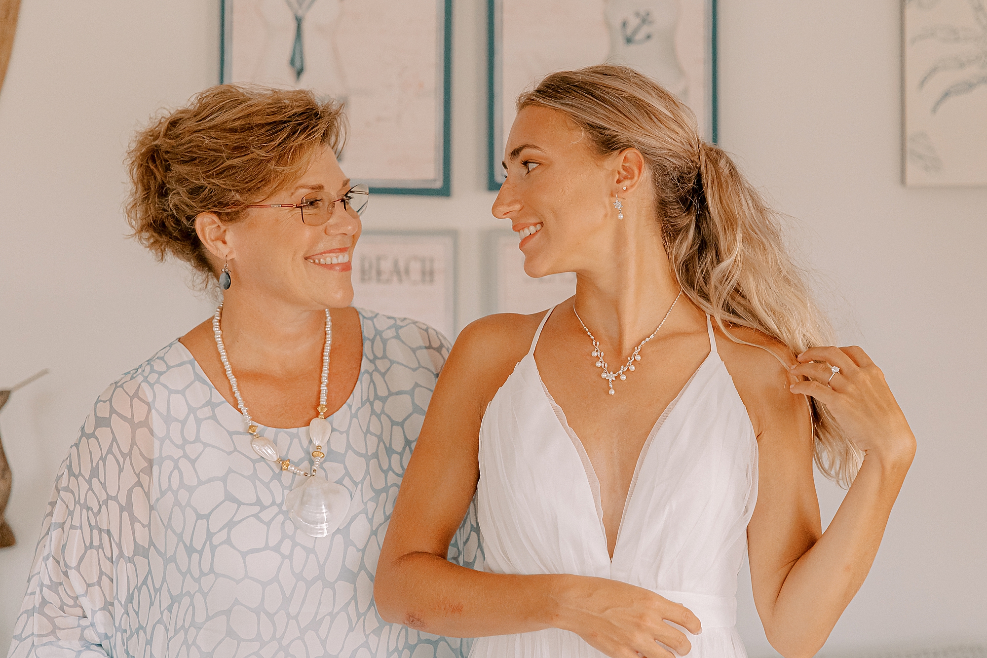 bride smiles at mother while preparing for OBX wedding day