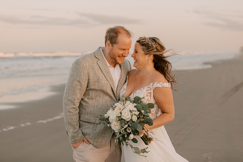 couple laughs together on the beach 