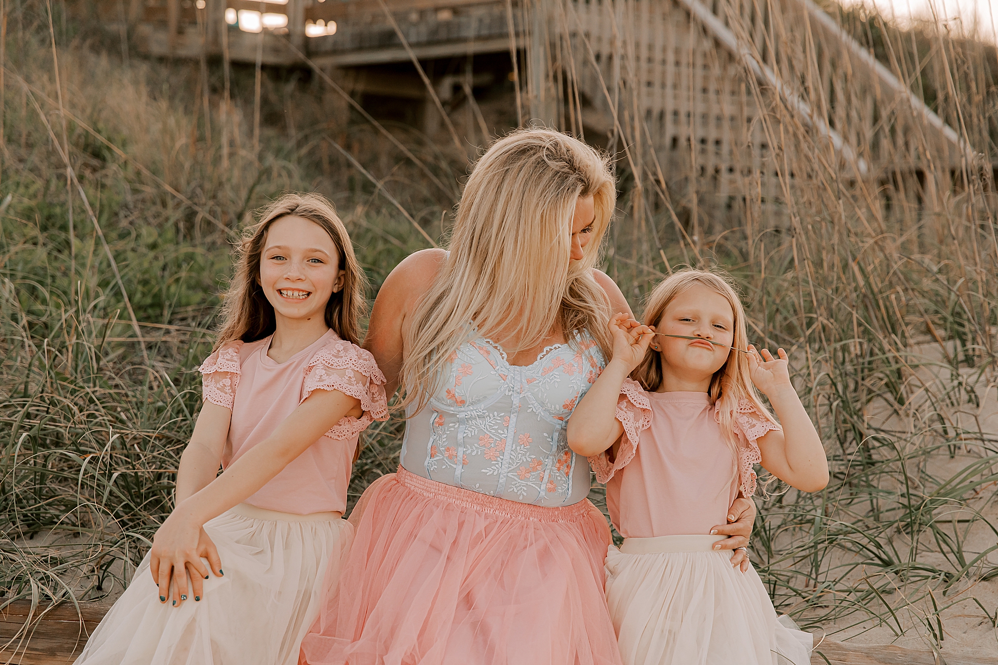 mom laughs with daughters during mommy + me photos at nags head pier