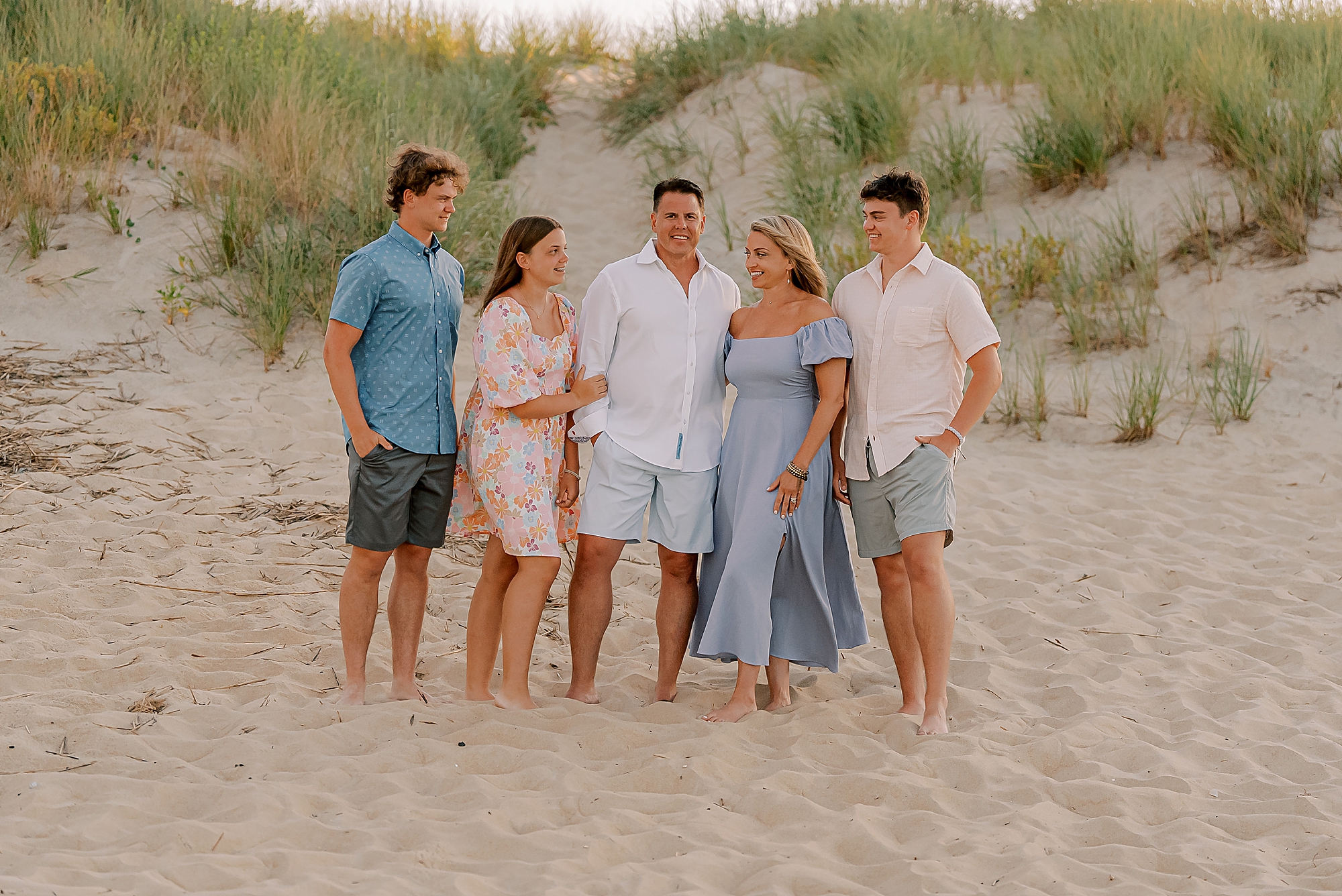 parents pose with three teenage children during outer banks family photos