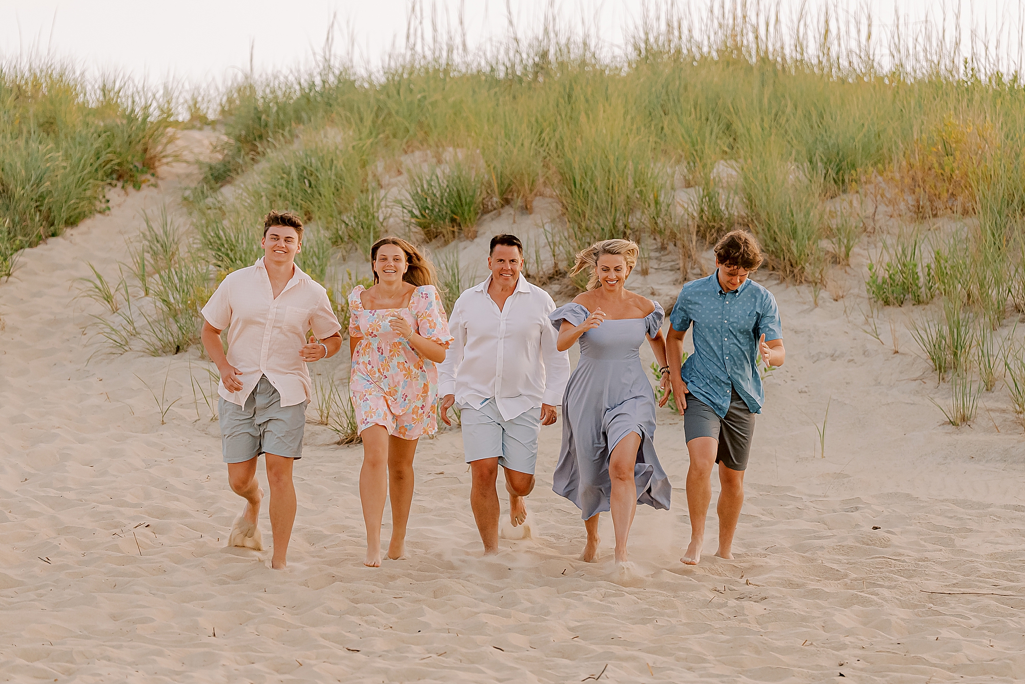 family of five runs across the sand during photos in kitty hawk nc