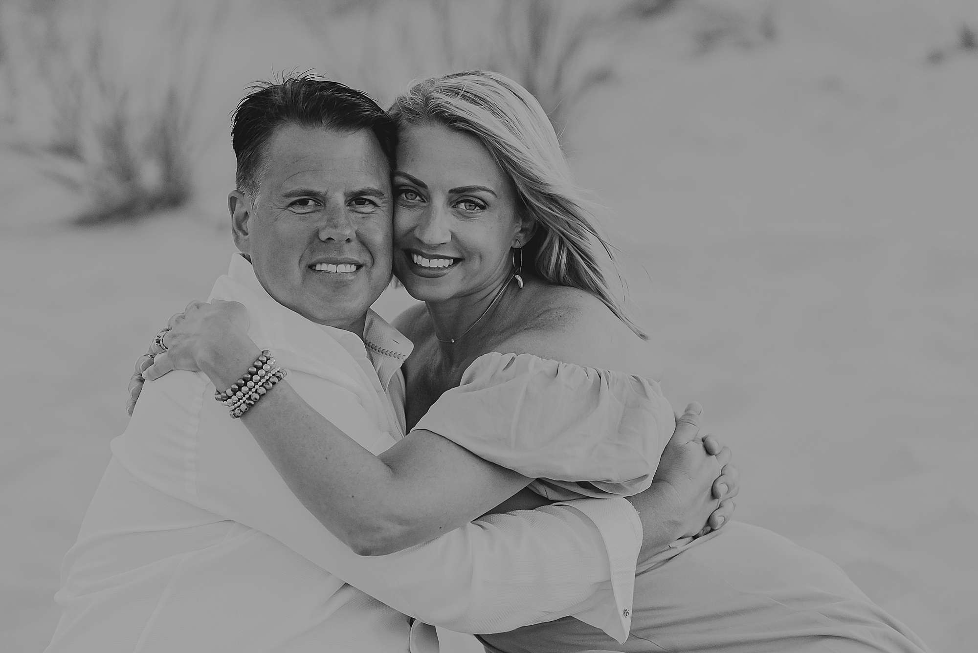 black and white photo of couple hugging on the beach in the outer banks