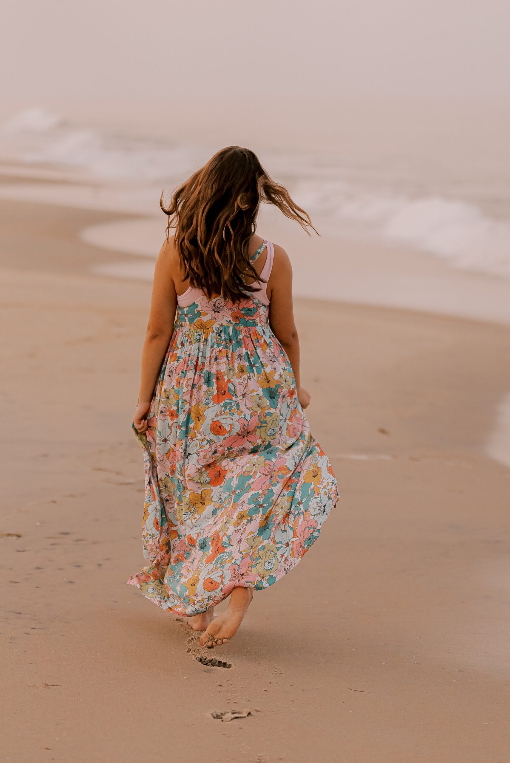 senior walks down beach during outer banks senior portraits