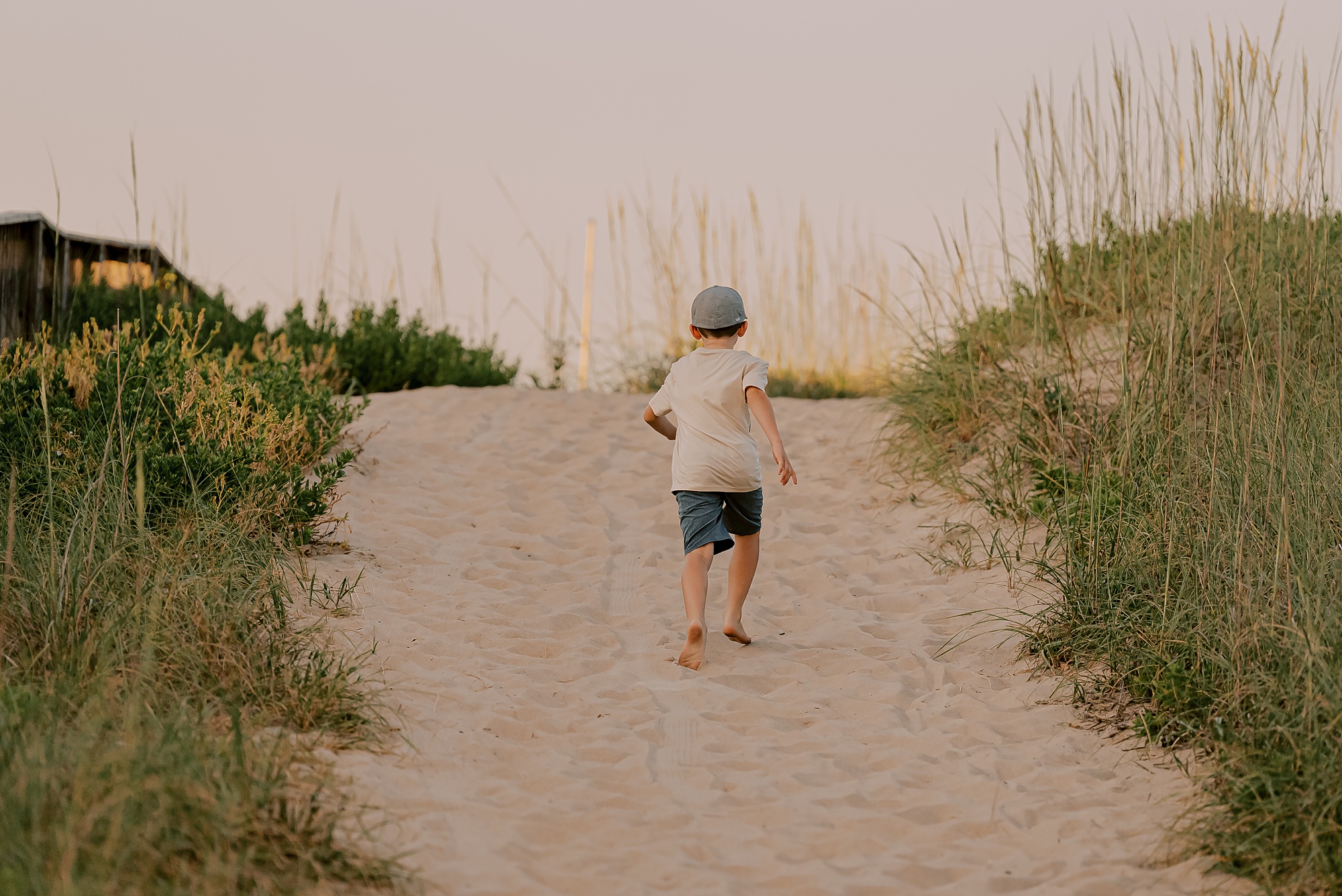 boy runs up sand dune on the outer banks