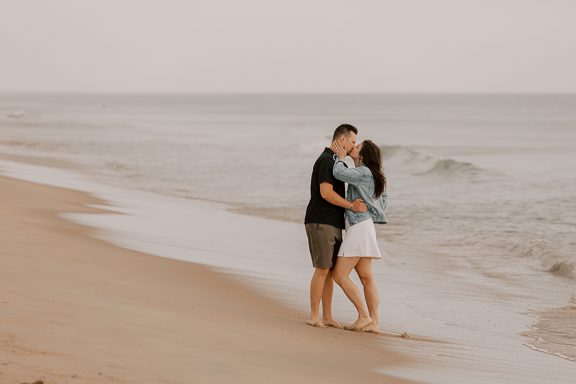 man kisses woman in surf on kitty hawk beach